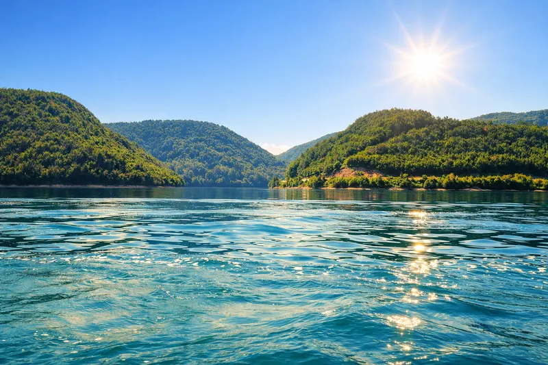 Jutarnji pogled na jezero okruženo zelenim planinama