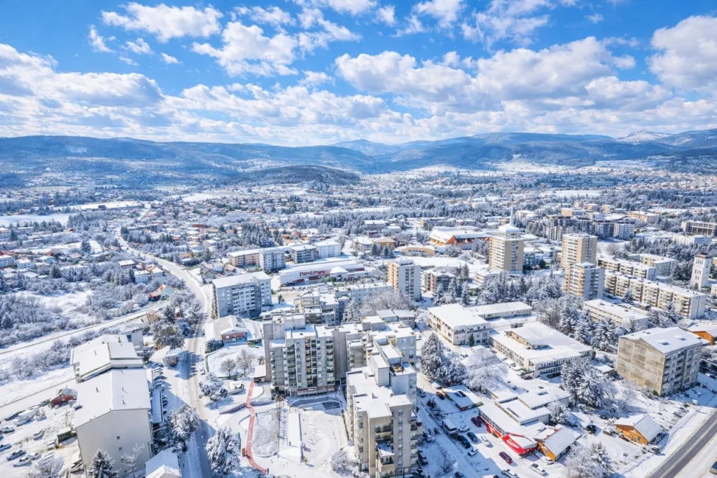 Bugojno pod snijegom, zimski pogled iz zraka na grad i okolinu